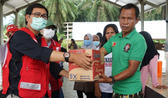 Wakil Ketua bidang penanggulangan bencana PMI Lutra, Suaib Mansur menyerahkan bantuan ke pengungsi banjir bandang di sekitar Pasar Baebunta, Sabtu (15/8/2020).