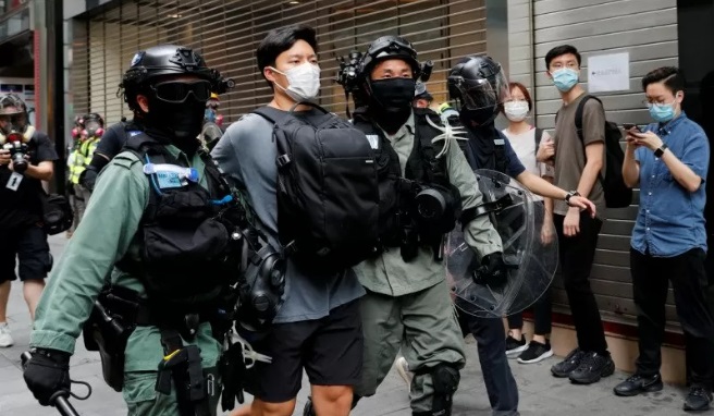 Polisi antihuru-hara menangkap seorang pengunjuk rasa selama protes atas pembacaan kedua undang-undang lagu kebangsaan kontroversial di Hong Kong, China, Rabu (27/5/2020). foto: reuters