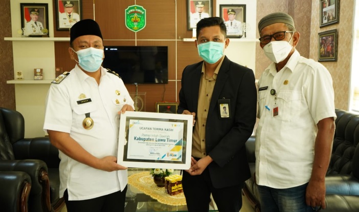 Manager PT PLN (Persero) ULP Malili, Tommi Ahmad menyerahkan piagam apresiasi atas kedisiplinan warga Luwu Timur melunasi tagihan listrik setiap bulan. ft/humaspemkablutim