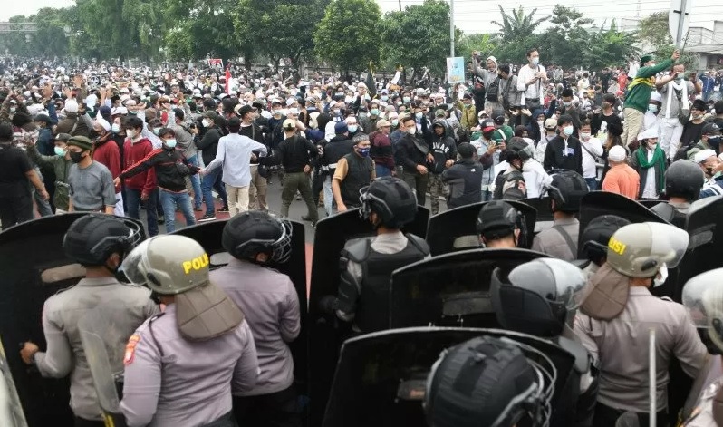Polisi memblokade massa pendukung Rizieq Shihab di kawasan I Gusti Ngurah Rai saat akan menuju Pengadilan Negeri (PN) Jakarta Timur, Kamis (24/6/2021). Massa pendukung tersebut akan menghadiri siidang pembacaan vonis kasus penyebaran kabar bohong tes usap COVID-19 di Rumah Sakit Ummi, Bogor. foto:antara