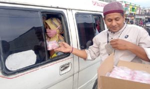 Jurnalis PPBC berbagi takjil kepada penumpang mobil angkutan umum di jalan Medan - Banda Aceh di Kota Lhokseumawe, Kamis (7/4/2022) sore. Foto:zul/teraskata.com