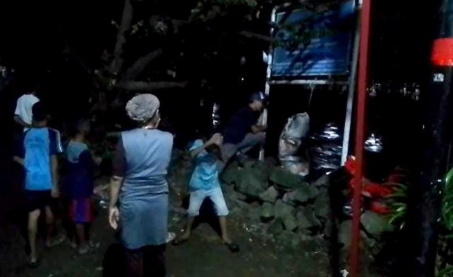 Warga Desa Panembahan, Kecamatan Plered dan Desa Setu Wetan, Kecamatan Weru, berjaga-jaga di pinggir sungai cipager akibat meningkatnya debit air secara signifikan, Rabu (25/3/2026) malam.