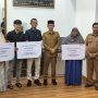 Bupati Aceh Barat Tarmizi S.P, M.M Didampingi Kepala BPJS Ketenagakerjaan Cabang Meulaboh Memberikan Secara Simbolis Kepada Ahli Wars Penerima Manfaat Santunan Kematian Dan Beasiswa. [Foto :Ist]